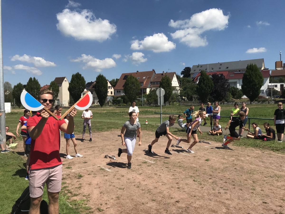 Hier sehen sie ein Bild zum Sporttag des PDG 2018. Es sind rennende Schüler zu sehen.